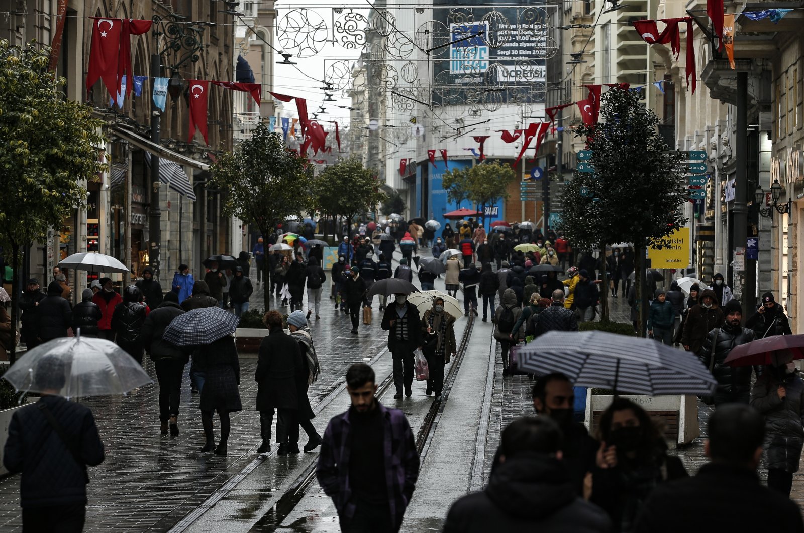 People walk in the rain on Istiklal Street, a major shopping street in Istanbul, Turkey, Feb. 3, 2022. (AP Photo)