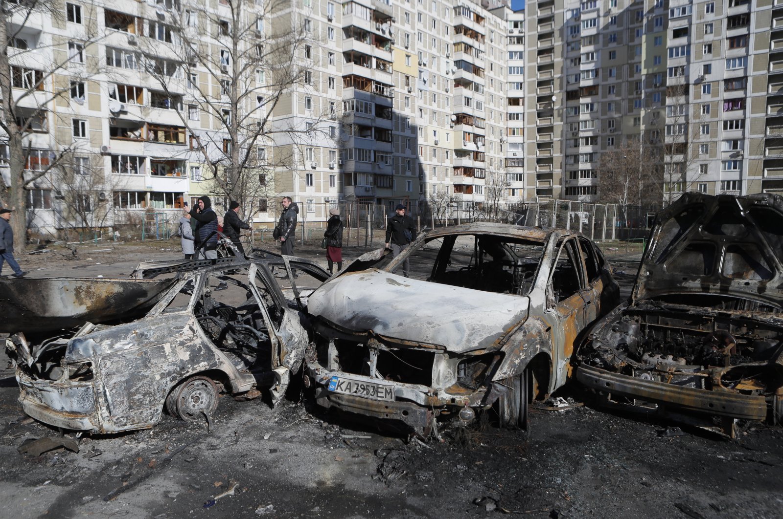 People walk past burned cars a day after shelling on a residential area in Kyiv, Ukraine, Feb. 28, 2022. (EPA Photo)