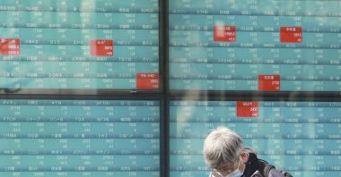 A man walks by an electronic stock board of a securities firm in Tokyo, Japan, Feb. 22, 2022. (AFP Photo)