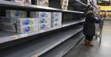  A woman looks over shelves, some of which are empty, at a Walmart store in Teterboro, N.J., U.S., Jan. 12, 2022. (AP Photo)