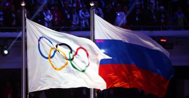 The Olympic flag (L) and the Russian flag on display at the Sochi 2014 Olympic Games closing ceremony, Sochi, Russia, Feb. 23, 2014 (EPA Photo)