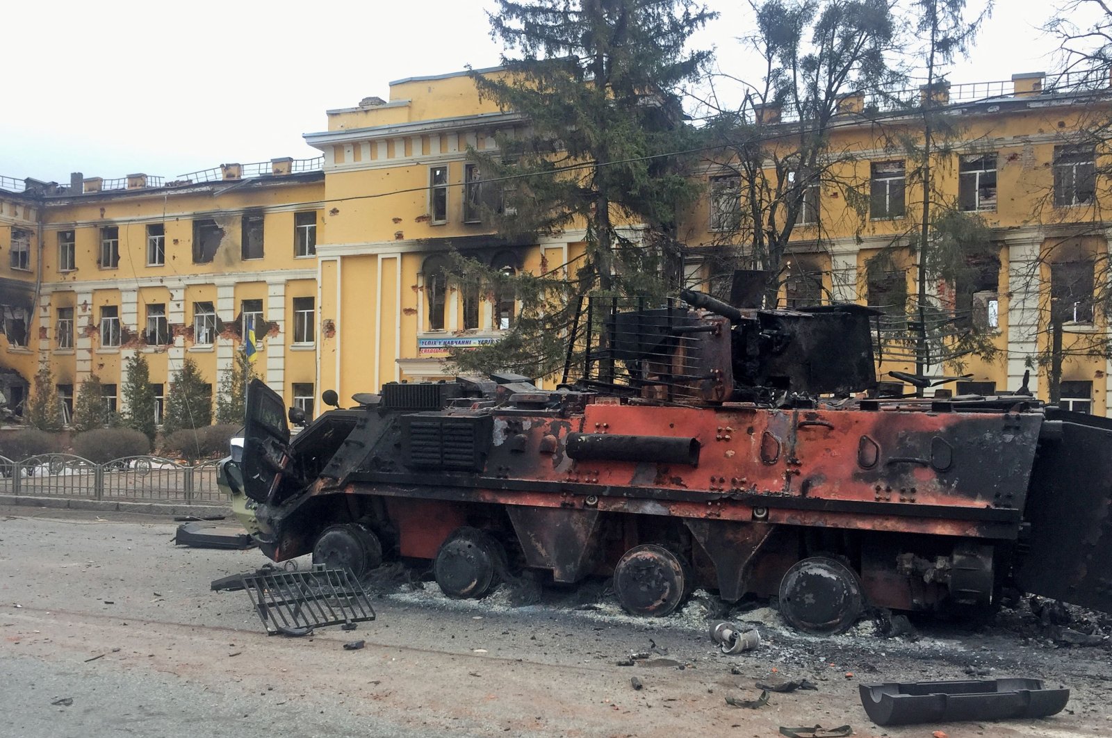 A destroyed armored vehicle is seen in front of a school which, according to local residents, was on fire after shelling, as Russia&#039;s invasion of Ukraine continues, in Kharkiv, Ukraine, Feb. 28, 2022. (Reuters Photo)