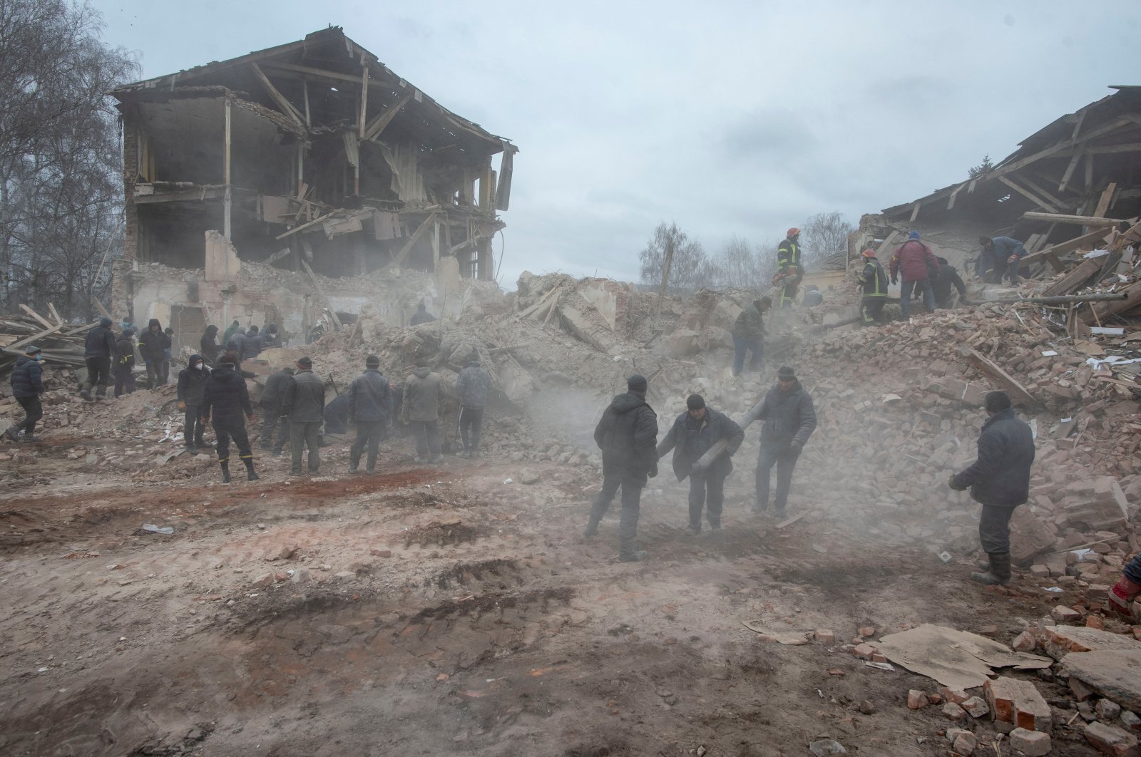 People remove debris at the site of a military base building that, according to the Ukrainian ground forces, was destroyed by an airstrike, in the town of Okhtyrka in the Sumy region, Ukraine, Feb. 28, 2022. (Irina Rybakova/Press service of the Ukrainian ground forces/Handout via Reuters)