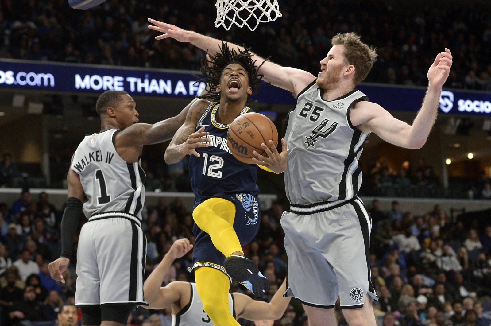 Memphis Grizzlies guard Ja Morant (C) jumps to shoot between two San Antonio Spurs players during an NBA game, Memphis, Tennesse, U.S., Feb. 28, 2022. (AP Photo)