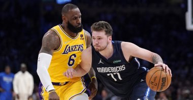 Mavericks' Luka Doncic (R) drives past Lakers' LeBron James during an NBA game, Los Angeles, California, U.S., March 1, 2022. (AP Photo)