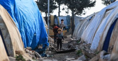 Internally displaced Syrians are pictured in front of tents in a camp, before being transported to a new housing complex in the opposition-held area of Bizaah, east of the city of al-Bab in the northern Aleppo governorate, built with the support of Turkey's emergencies agency AFAD, Syria, Feb. 9, 2022. (AFP Photo)