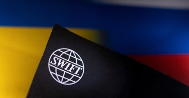 A SWIFT logo is placed on Ukrainian's and Russian's flag colors in this illustration photo, Bosnia-Herzegovina, Feb. 25, 2022. (Reuters Photo)
