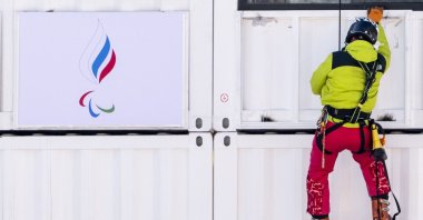 A man hangs a Russian Paralympic Committee flag in Yanqing, China, March 2, 2022. (EPA Photo)