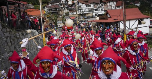 People in Jokimi costumes attend a parade during a carnival celebration in Colonia Tovar, Venezuela, Feb. 26, 2022. (AP Photo)