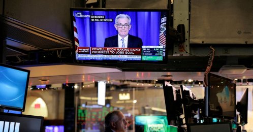 U.S. Federal Reserve (Fed) Chair Jerome Powell is seen delivering remarks on a screen as a trader works on the trading floor at the New York Stock Exchange (NYSE) in Manhattan, New York City, U.S., Dec. 15, 2021. (Reuters Photo)