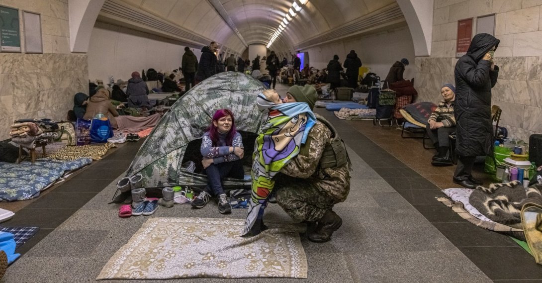A Ukrainian military member who came inside Dorohozhychi subway station which is used as a bomb shelter, hugs his son staying there, in Kyiv, Ukraine, 02 March 2022. (EPA Photo)