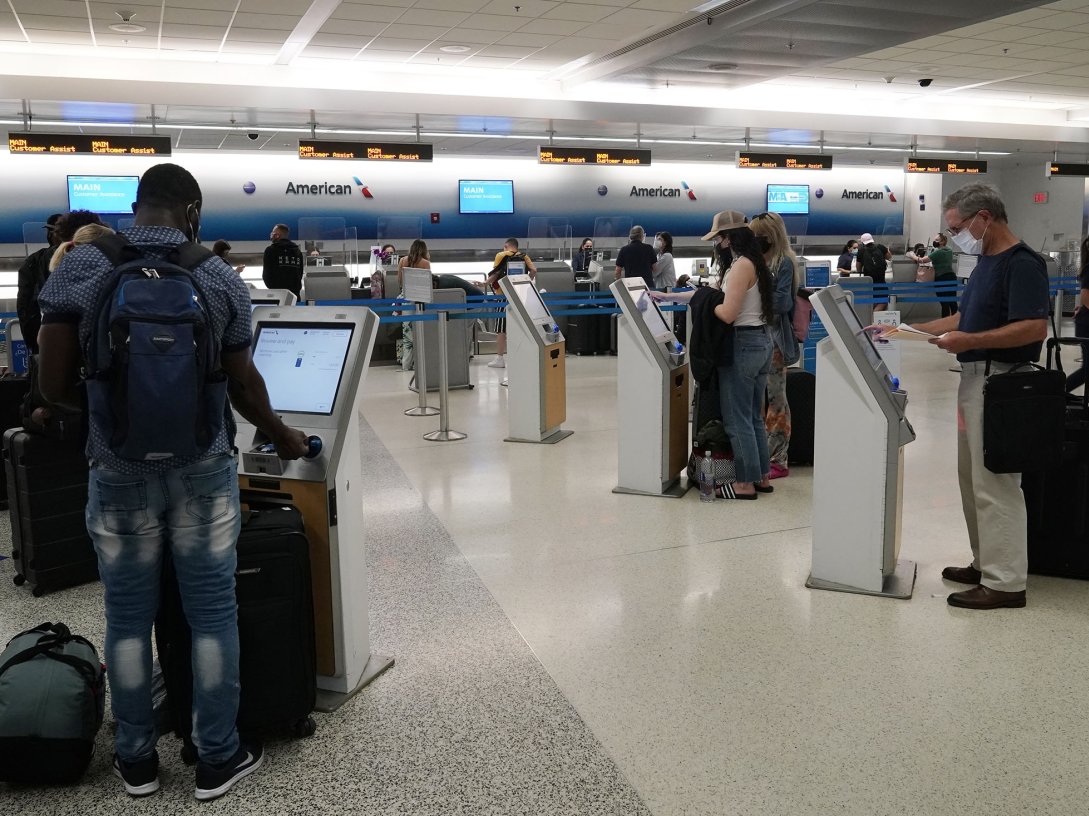 Travelers use the self-service kiosk to check in and pay for luggage at the American Airlines terminal, in Miami, U.S., April 29, 2021. (AP Photo)