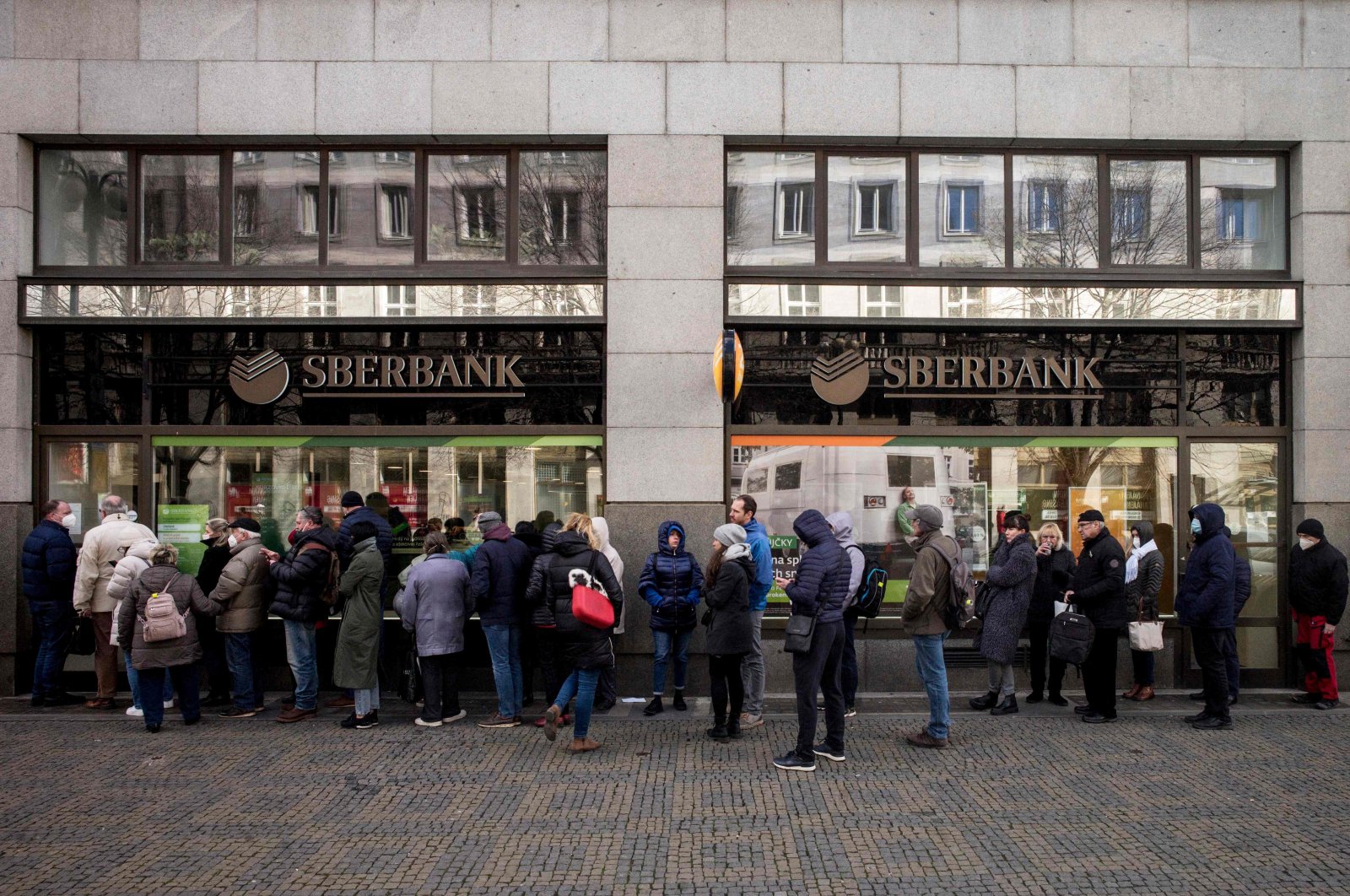 People queue outside a branch of the Russian state-owned bank Sberbank to withdraw their savings and close their accounts in Prague, Czech Republic, Feb. 25, 2022. (AFP Photo)