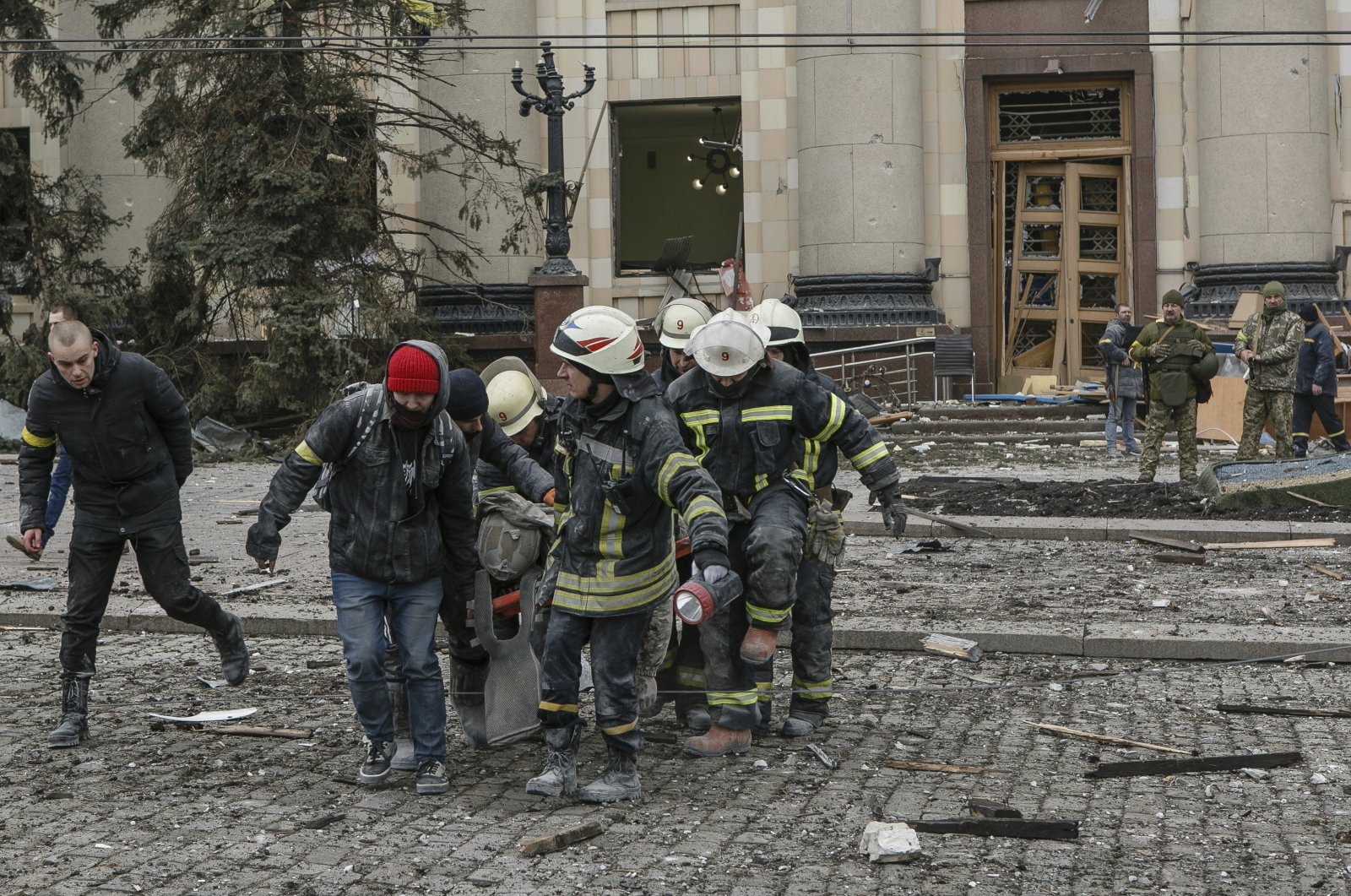 Ukrainian emergency service personnel carry the body of a victim out of the damaged City Hall building following shelling in Kharkiv, Ukraine, March 1, 2022. (AP Photo)
