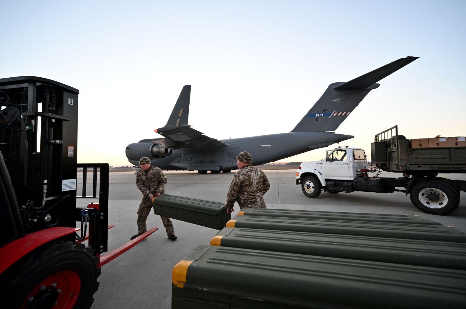 Servicemen of Ukrainian Military Forces move U.S.-made FIM-92 Stinger missiles, a man-portable air-defense system (MANPADS), that operates as an infrared homing surface-to-air missile (SAM), and the other military assistance shipped from Lithuania to Boryspil Airport in Kyiv, Ukraine, Feb. 13, 2022. (AFP Photo)