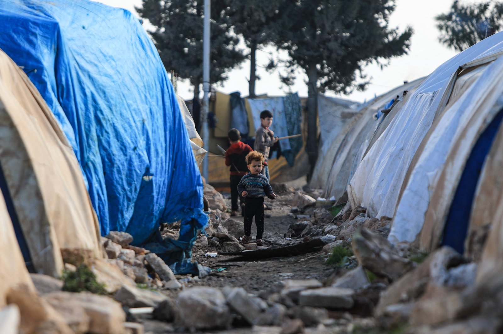 Internally displaced Syrians are pictured in front of tents in a camp, before being transported to a new housing complex in the opposition-held area of Bizaah, east of the city of al-Bab in the northern Aleppo governorate, built with the support of Turkey&#039;s emergencies agency AFAD, Syria, Feb. 9, 2022. (AFP Photo)