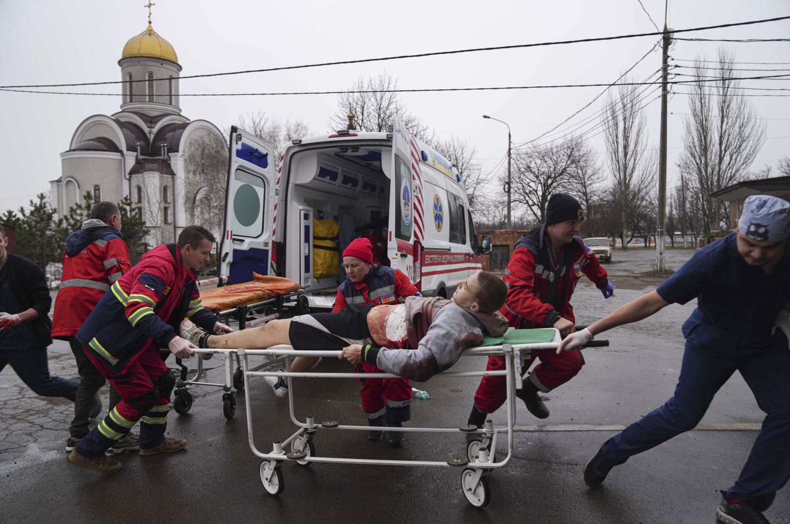 Ambulance paramedics move an injured man on a stretcher, wounded by shelling in a residential area, at a maternity hospital converted into a medical ward and used as a bomb shelter in Mariupol, Ukraine, March 1, 2022. (AP Photo)