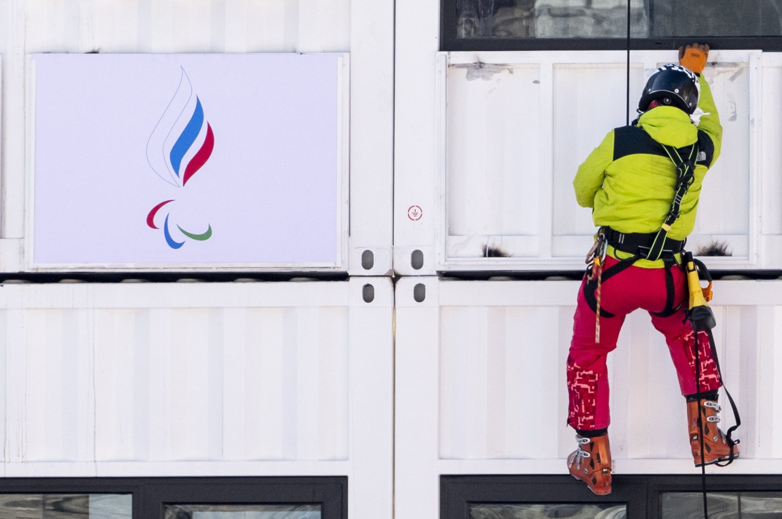 A man hangs a Russian Paralympic Committee flag in Yanqing, China, March 2, 2022. (EPA Photo)