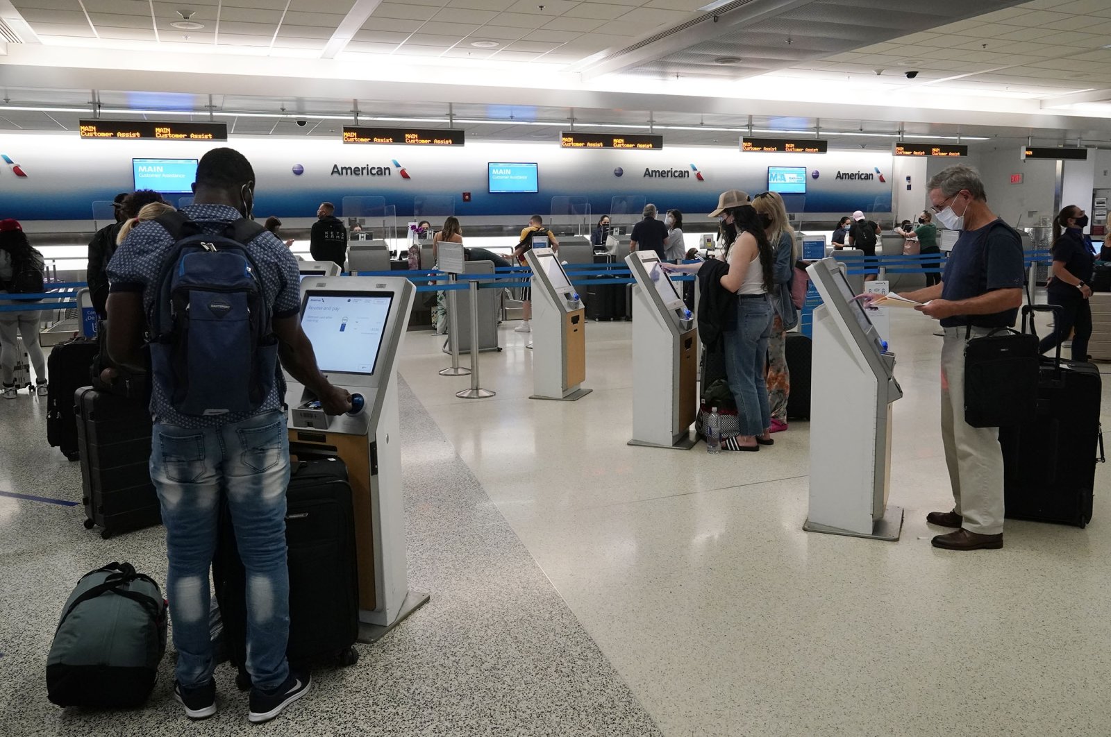 Travelers use the self-service kiosk to check in and pay for luggage at the American Airlines terminal, in Miami, U.S., April 29, 2021. (AP Photo)