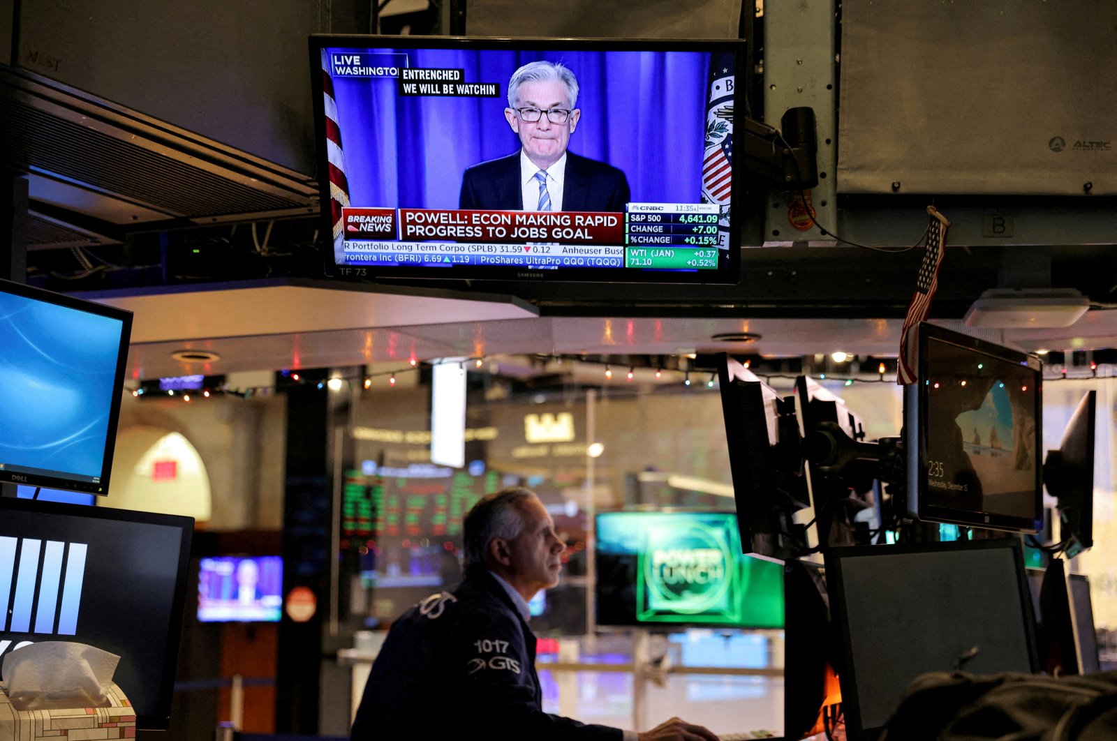 U.S. Federal Reserve (Fed) Chair Jerome Powell is seen delivering remarks on a screen as a trader works on the trading floor at the New York Stock Exchange (NYSE) in Manhattan, New York City, U.S., Dec. 15, 2021. (Reuters Photo)