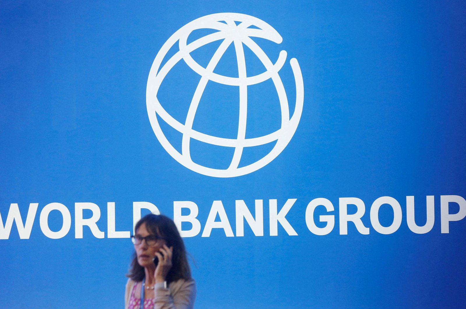 A participant stands near a logo of the World Bank at the International Monetary Fund - World Bank Annual Meeting 2018 in Nusa Dua, Bali, Indonesia, Oct. 12, 2018. (Reuters Photo)