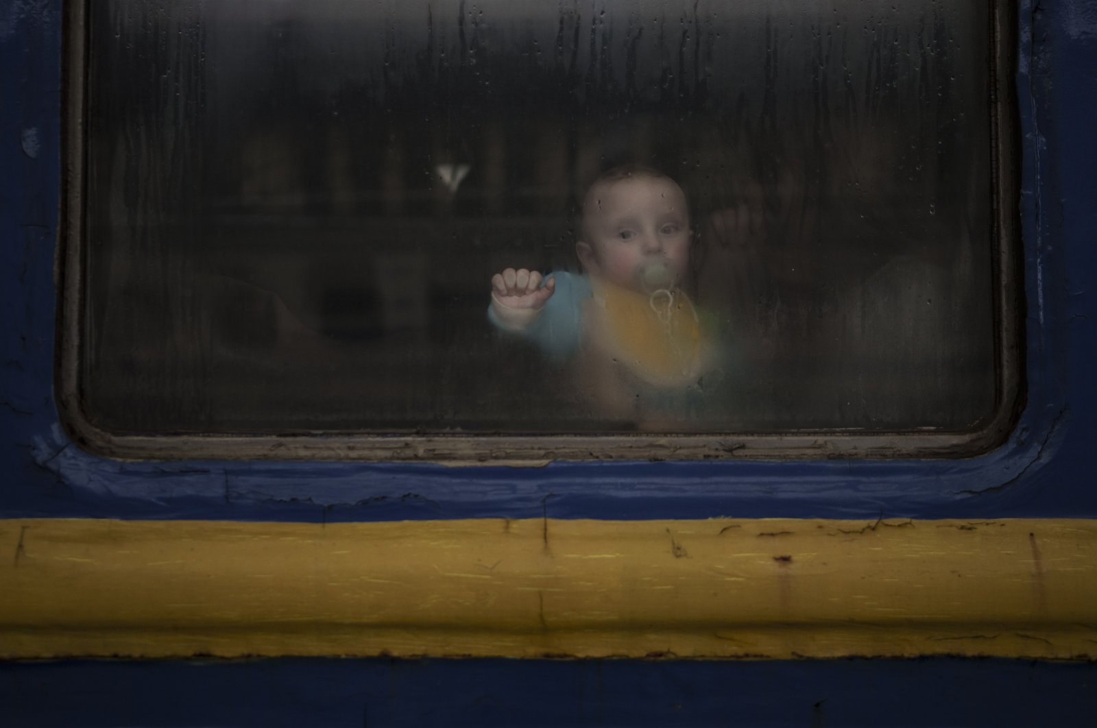 A baby sits with his mother inside a train leaving the Lviv railway station, in Lviv, west Ukraine, March 2, 2022. (AP Photo)