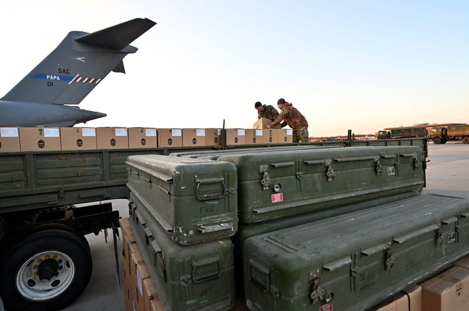 Ukrainian Military Forces soldiers load a flat bed truck with boxes as U.S.-made FIM-92 Stinger missiles (F), a man-portable air-defense system (MANPADS) that operates as an infrared homing surface-to-air missile (SAM), are stacked after being shipped to Boryspil Airport, Kyiv, Ukraine, Feb. 13, 2022. (AFP Photo)