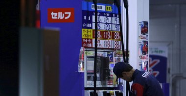 An employee of Cosmo Energy Holdings&#039; Cosmo Oil service station checks its nozzles at a branch in Tokyo, Japan, Dec. 16, 2015. (Reuters Photo)