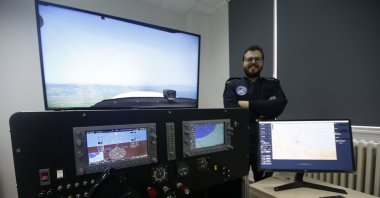 Emre Bulat poses next to the flight simulator in Samsun, northern Turkey, March 4, 2022. (AA PHOTO)