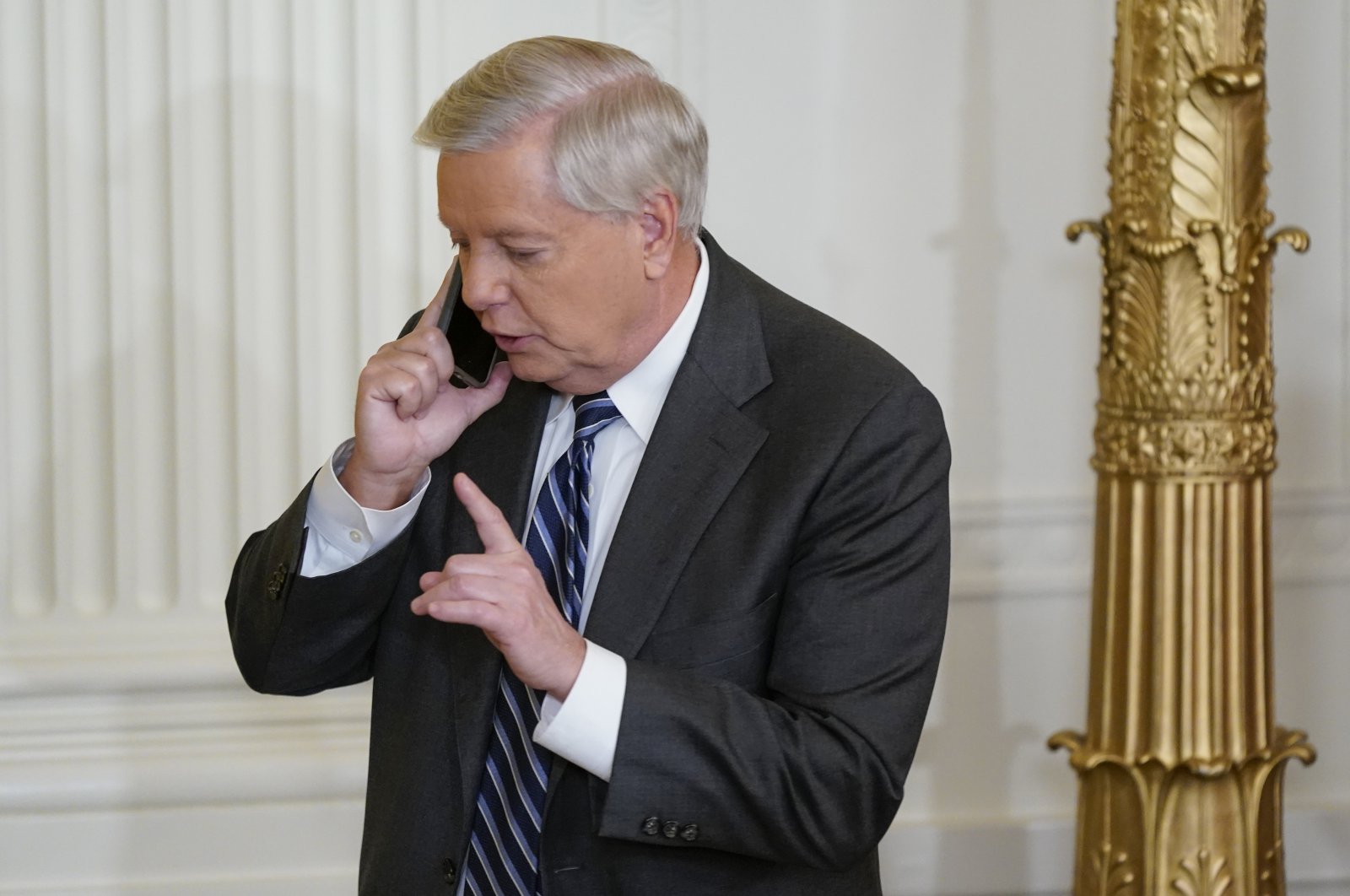 Sen. Lindsey Graham, R-S.C., talks on the phone in the East Room of the White House in Washington, U.S., March 3, 2022. (AP Photo)