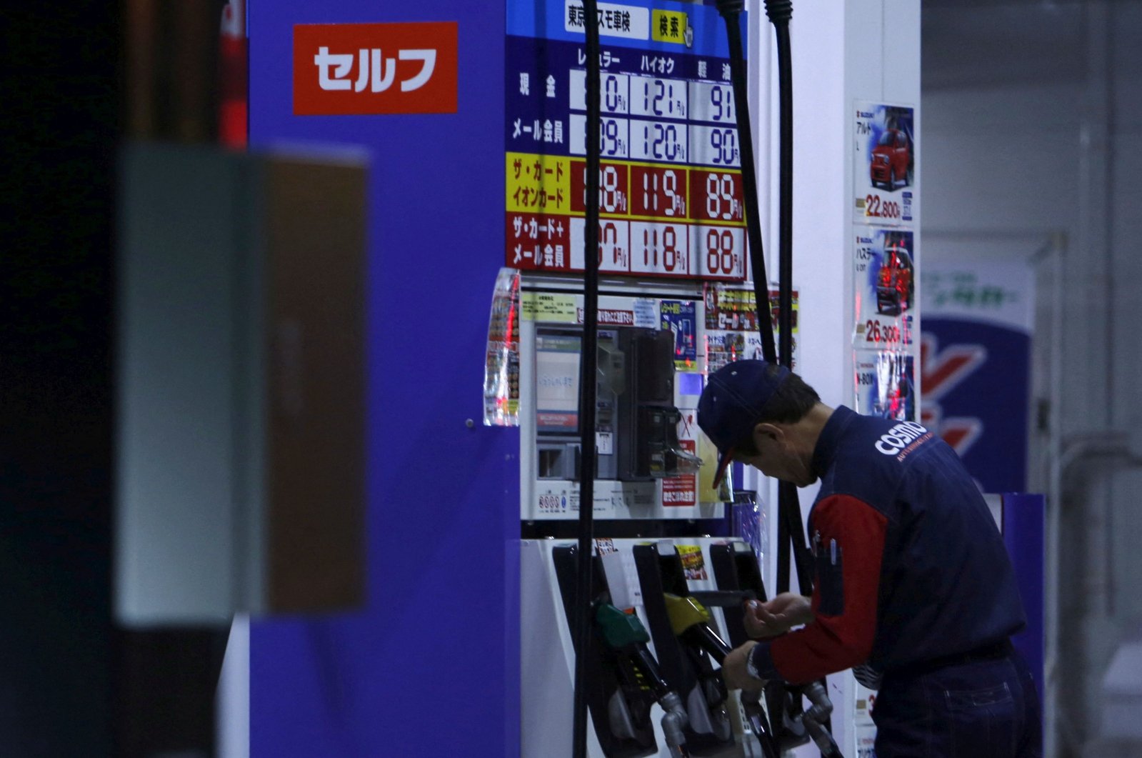 An employee of Cosmo Energy Holdings&#039; Cosmo Oil service station checks its nozzles at a branch in Tokyo, Japan, Dec. 16, 2015. (Reuters Photo)