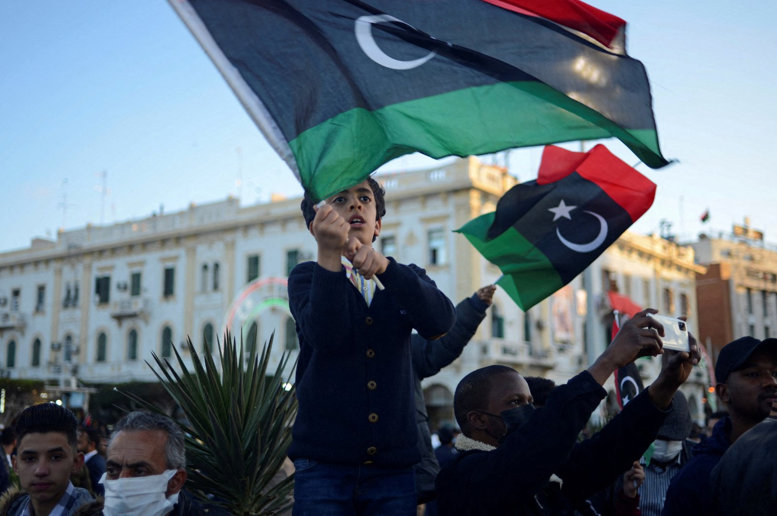A boy waves a Libyan flag as people gather during celebrations commemorating the 11th anniversary of the 2011 revolution in Tripoli, Libya, Feb. 18, 2022. (REUTERS Photo)