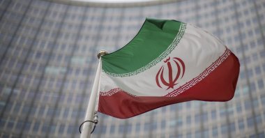 A national flag of Iran waves in front of the building of the International Atomic Energy Agency, IAEA, in Vienna, Austria, Dec. 17, 2021. (AP Photo)