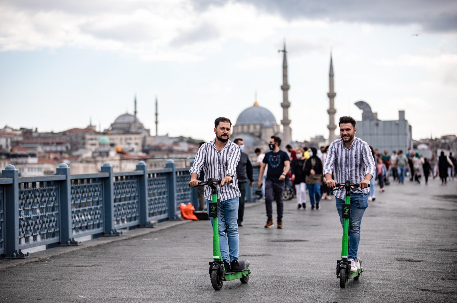 People are seen riding Martı e-scooters on Istanbul&#039;s Galata Bridge, Turkey, Sept. 6, 2021. (Onur Dogman/SOPA Images/Sipa USA via Reuters)
