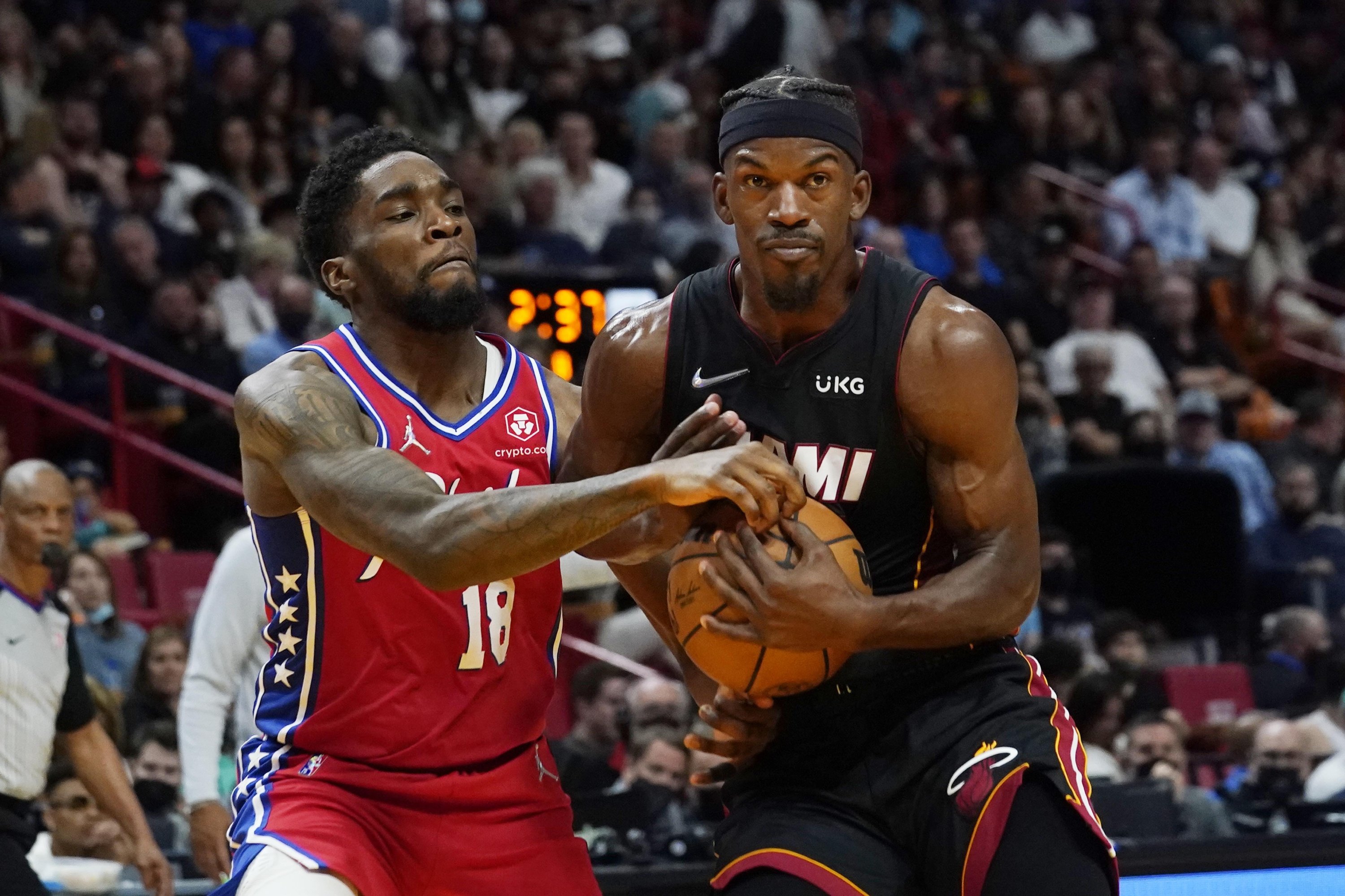 Heat forward Jimmy Butler (kanan) menjaga bola saat guard Sixers Shake Milton (18) bertahan selama paruh kedua pertandingan bola basket NBA, Sabtu, 5 Maret 2022, di Miami.  (Foto AP)