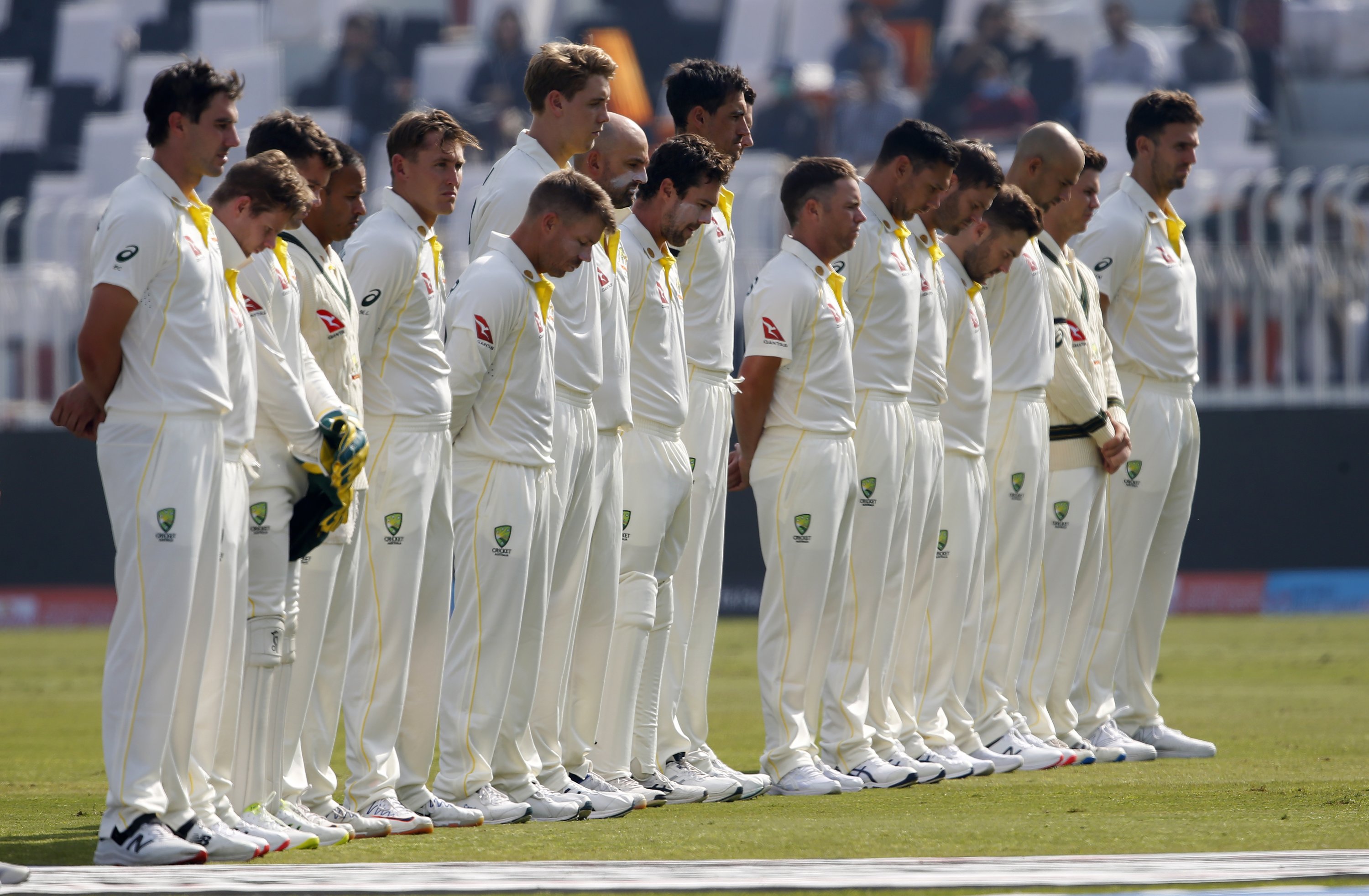 Para pemain Australia mengheningkan cipta selama satu menit sebagai penghormatan kepada legenda kriket Shane Warne sebelum hari kedua Tes pertama melawan Pakistan, Rawalpindi, Pakistan, 5 Maret 2022. (AP Photo)