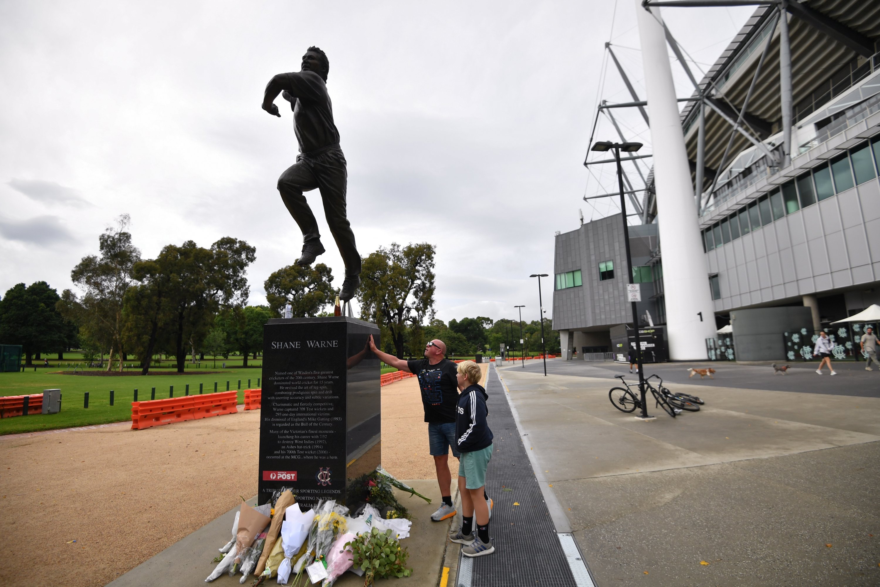 Orang-orang memberikan penghormatan di patung Shane Warne setelah kematiannya, Melbourne, Australia, 5 Maret 2022. (EPA Photo)