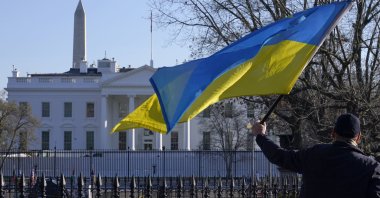 A protester waves a Ukranian flag in front of the White House amid the Russian invasion of Ukraine, Washington, D.C., U.S., March 4, 2022. (AP Photo)