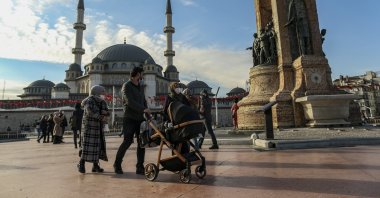 People wearing masks walk in Taksim Square in Istanbul, Turkey, Feb. 5, 2022. (AP File Photo)