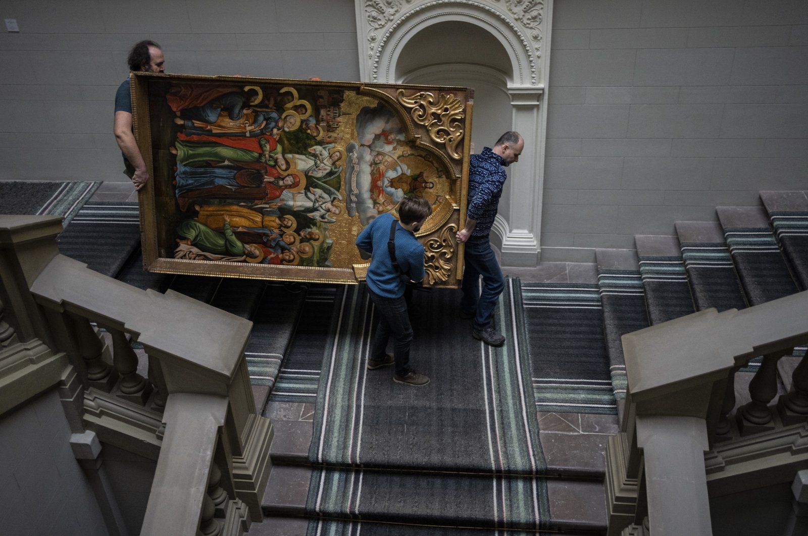 Workers move the Annunciation to the Blessed Virgin of the Bohorodchany Iconostasis in the Andrey Sheptytsky National Museum as part of safety preparations in the event of an attack in the western Ukrainian city of Lviv, Friday, March 4, 2022. (AP)