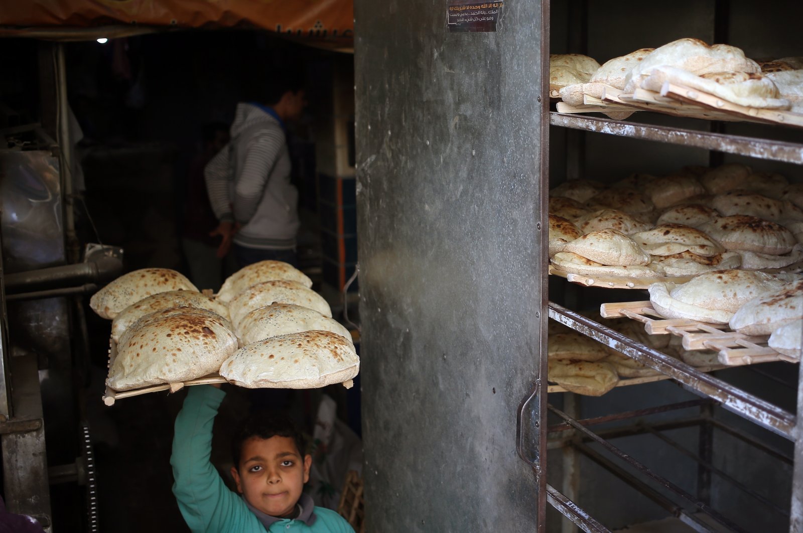 An Egyptian baker carries bread at a bakery in Cairo, Egypt, March 3, 2022. (EPA Photo)