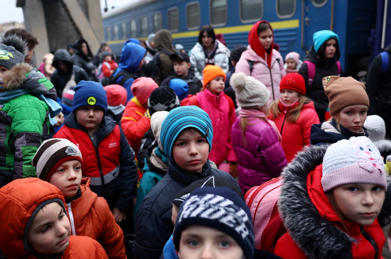 A group of children evacuated from an orphanage in Zaporizhzhia wait to board a bus for their transfer to Poland after fleeing the ongoing Russian invasion at the main train station in Lviv, Ukraine, March 5, 2022. (Reuters Photo)