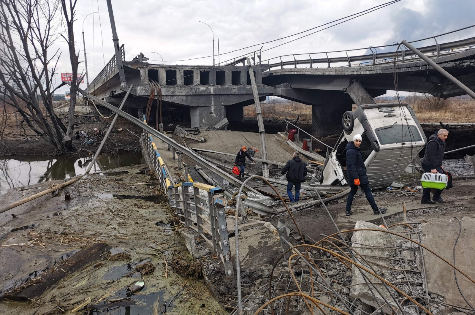Pedestrians cross a destroyed bridge as they evacuate the city of Irpin, northwest of Kyiv, Ukraine, March 6, 2022. (AFP Photo)