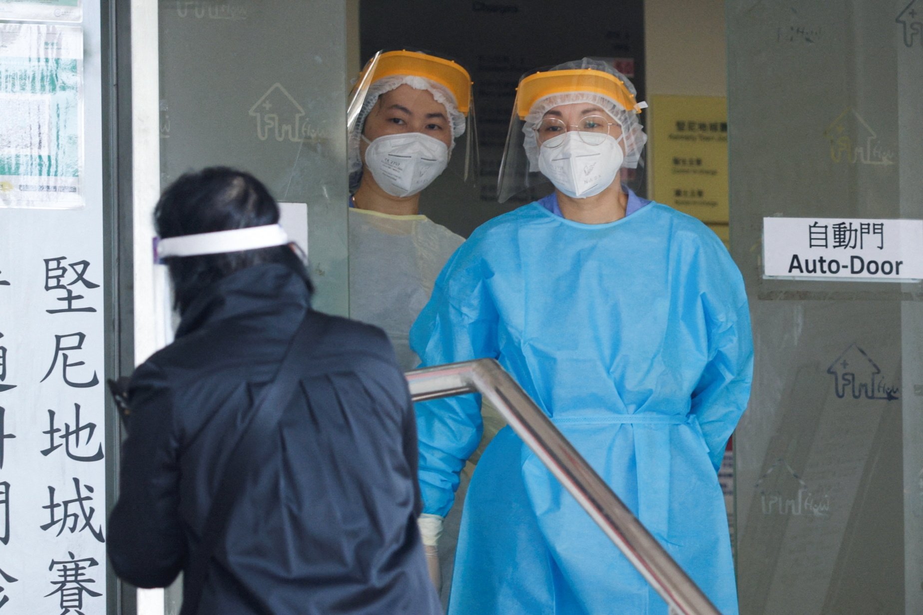 Petugas kesehatan yang mengenakan alat pelindung diri berdiri di sebuah klinik yang ditunjuk untuk merawat pasien virus corona, di Hong Kong, Cina, 7 Maret 2022. (Foto Reuters)