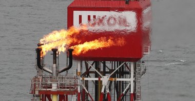 A gas torch is seen next to the Lukoil company sign at the Filanovskogo oil platform in the Caspian Sea, Russia, Oct. 16, 2018. (Reuters Photo)