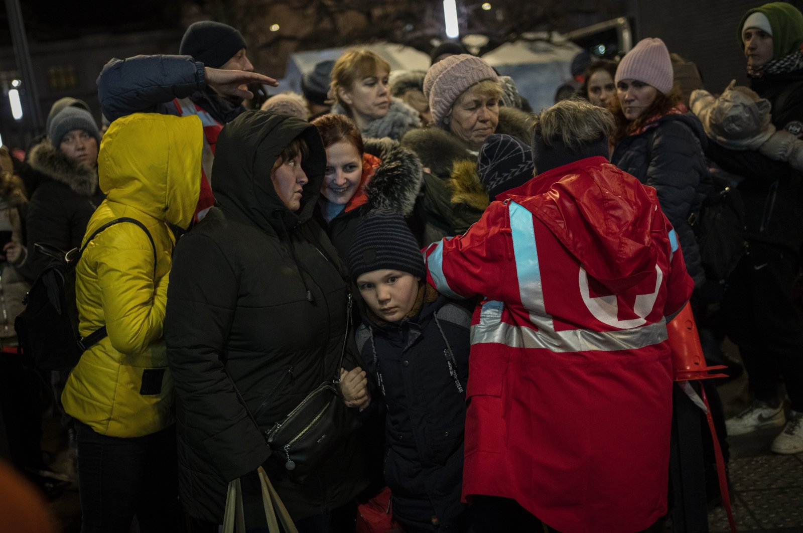 Displaced Ukrainians queue to board a bus to Poland outside Lviv train station in western Ukraine, March 5, 2022. (AP Photo)