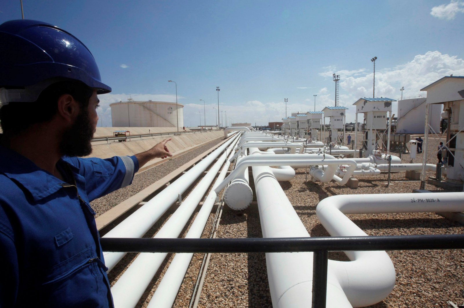 A worker gestures towards pipelines at the port and Zawiya Oil Refinery, Aug. 22, 2013. (Reuters Photo)
