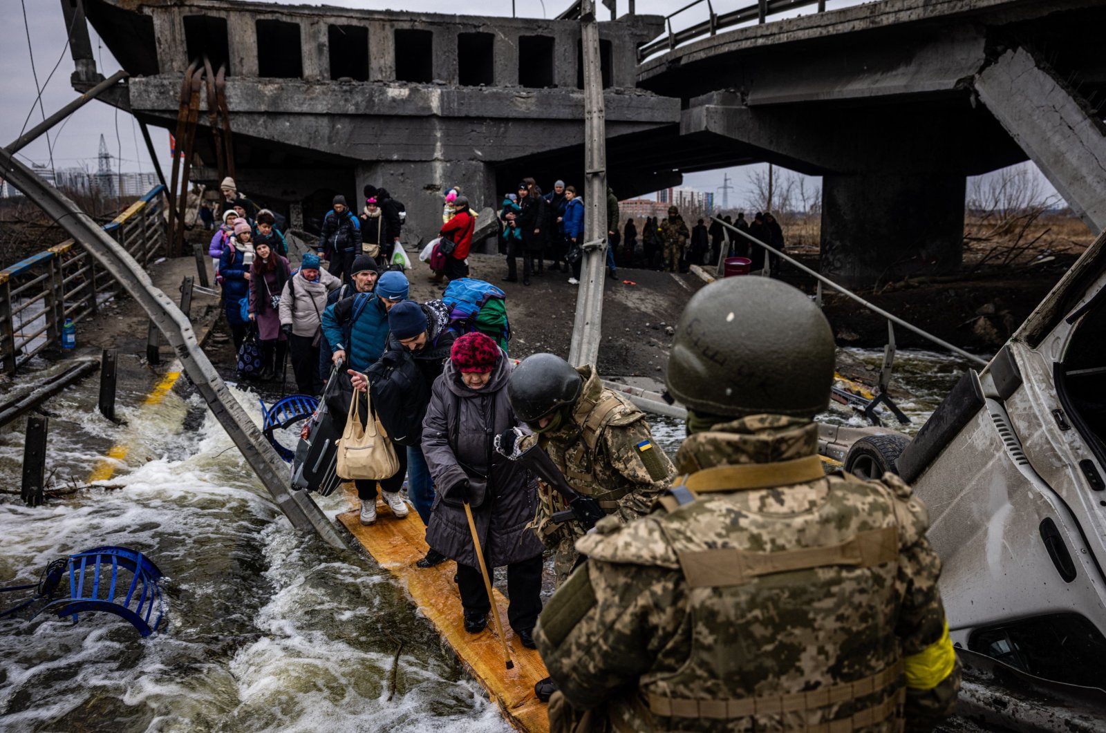 Evacuees cross a destroyed bridge as they flee the city of Irpin, northwest of Kyiv, Ukraine, March 7, 2022. (AFP Photo)