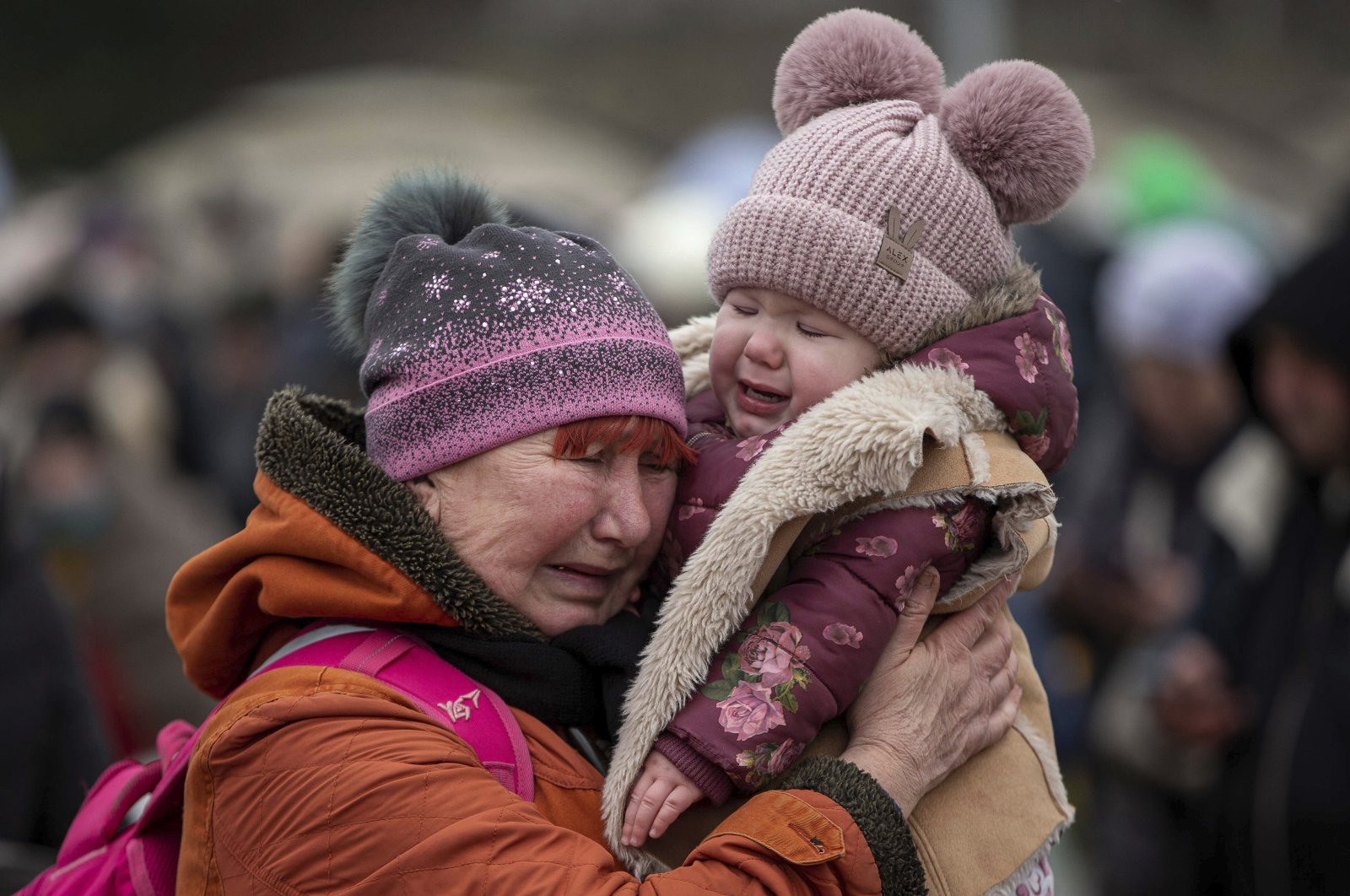 A woman holding a child cries after fleeing from Ukraine and arriving at the border crossing in Medyka, Poland, March 7, 2022. (AP Photo)