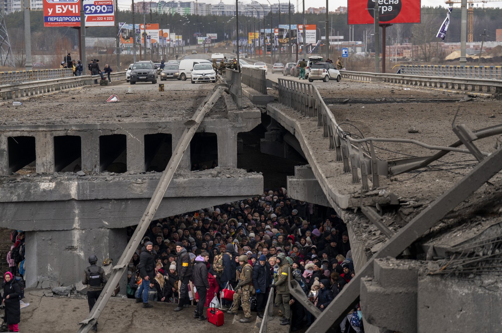 Ukrainians crowd under a destroyed bridge as they try to flee crossing the Irpin river in the outskirts of Kyiv, Ukraine, March 5, 2022. (AP Photo)
